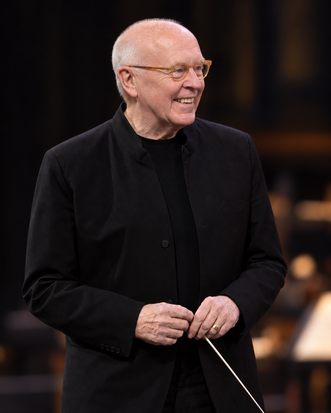 Peter Stark smiling and holding a conductor’s baton